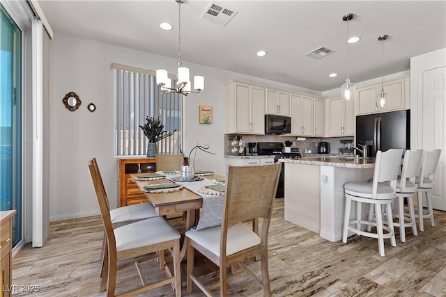 10052 Silver Comet Ct, Las Vegas, NV 89178 - kitchen with black appliances, light wood finished floors, a chandelier, recessed lighting, and tasteful backsplash