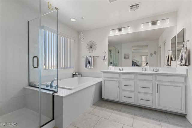 10052 Silver Comet Ct, Las Vegas, NV 89178 - bathroom featuring double vanity, a shower stall, a garden tub, and tile patterned flooring