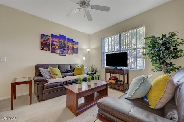 living area featuring light colored carpet, baseboards, and ceiling fan