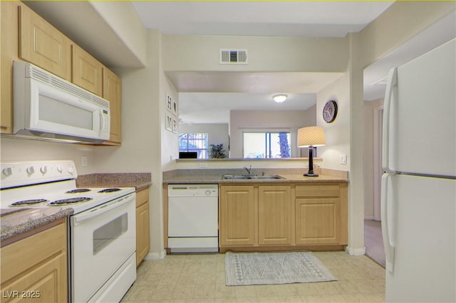 kitchen with light brown cabinets, a sink, white appliances, and visible vents