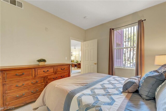 bedroom featuring visible vents and light colored carpet