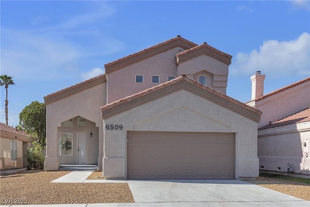 6509 Old Oxford Ave, Las Vegas, NV 89108 - mediterranean / spanish house featuring concrete driveway, a tiled roof, an attached garage, and stucco siding