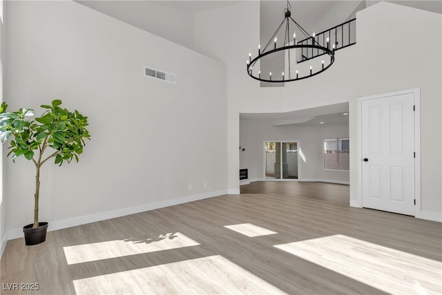 6509 Old Oxford Ave, Las Vegas, NV 89108 - unfurnished dining area with a towering ceiling, baseboards, a chandelier, visible vents, and wood finished floors