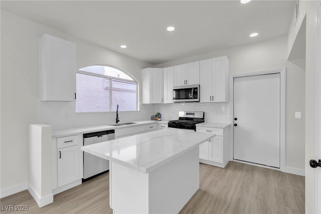 6509 Old Oxford Ave, Las Vegas, NV 89108 - kitchen with a sink, light wood-type flooring, appliances with stainless steel finishes, and white cabinets