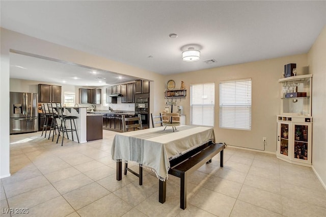 dining space with light tile patterned floors, baseboards, and visible vents