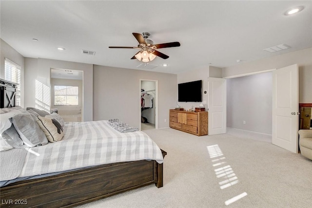carpeted bedroom with ceiling fan, a spacious closet, visible vents, and recessed lighting