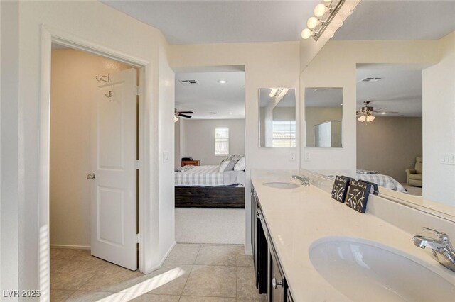 bathroom featuring a sink, ceiling fan, double vanity, ensuite bath, and tile patterned flooring