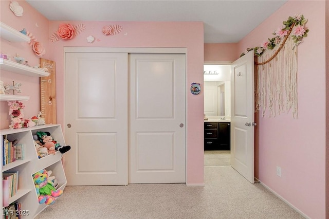 recreation room featuring baseboards and light colored carpet
