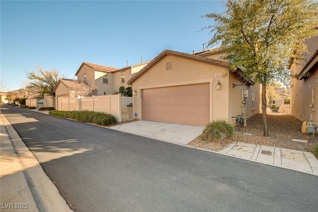 townhome / multi-family property with concrete driveway, stucco siding, a tile roof, a garage, and fence