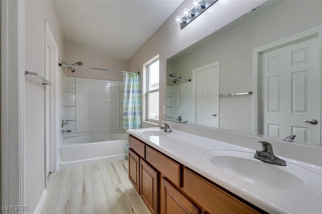 full bath featuring wood finished floors, shower / bath combination with curtain, a sink, and lofted ceiling
