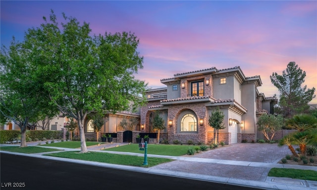 15 Vintage Canyon St, Las Vegas, NV 89141 - mediterranean / spanish-style house with stucco siding, stone siding, decorative driveway, an attached garage, and a front lawn