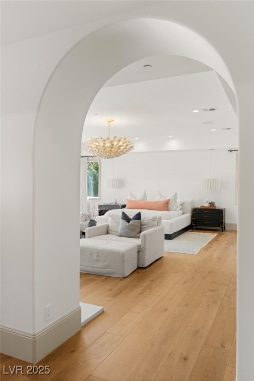 15 Vintage Canyon St, Las Vegas, NV 89141 - living room with arched walkways, visible vents, light wood-type flooring, and an inviting chandelier