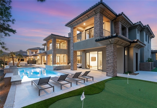 15 Vintage Canyon St, Las Vegas, NV 89141 - back of property with stucco siding, a patio area, stone siding, a balcony, and an outdoor pool