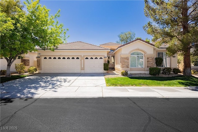 view of front facade with a tiled roof, driveway, a garage, and stucco siding