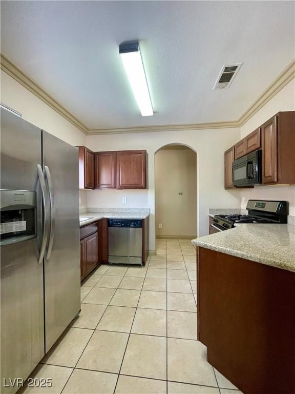 kitchen with stainless steel appliances, arched walkways, light tile patterned floors, crown molding, and a peninsula