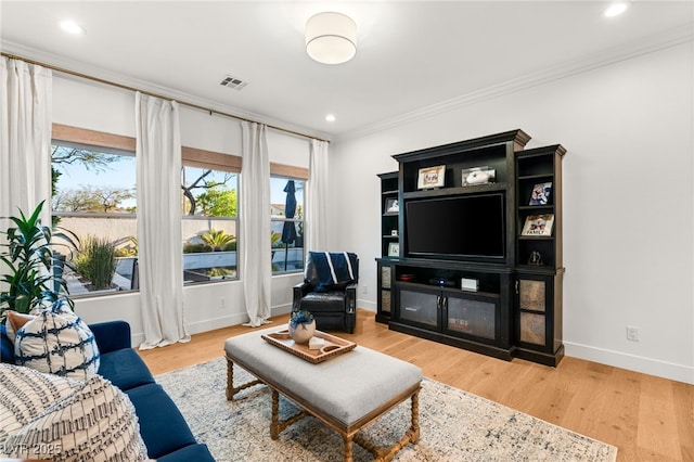 living area with crown molding, baseboards, light wood-type flooring, and recessed lighting