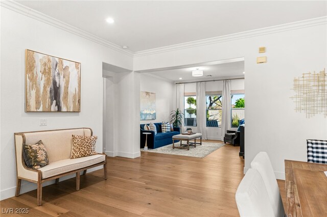 sitting room featuring light wood-type flooring, crown molding, baseboards, and recessed lighting