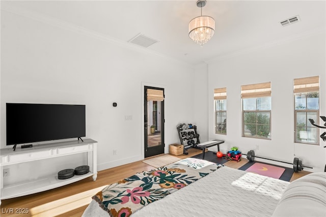 bedroom featuring crown molding, wood finished floors, a chandelier, a baseboard radiator, and baseboards