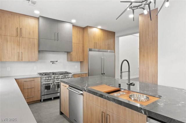 2236 Timber Rose Dr, Las Vegas, NV 89134 - kitchen with premium appliances, modern cabinets, a sink, and dark stone countertops