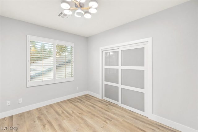 2236 Timber Rose Dr, Las Vegas, NV 89134 - unfurnished room with light wood-style flooring, visible vents, baseboards, and a notable chandelier