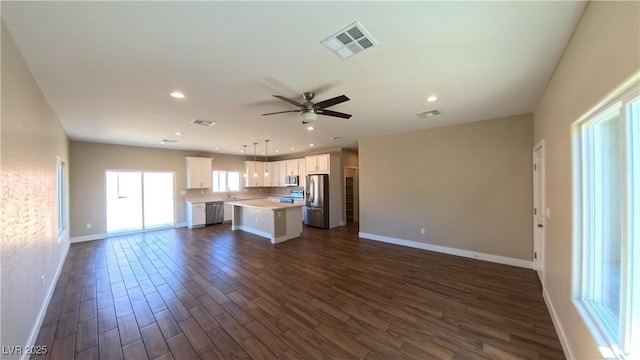 kitchen with appliances with stainless steel finishes, open floor plan, visible vents, and light countertops