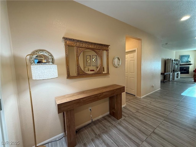 hallway featuring tile patterned floors and baseboards