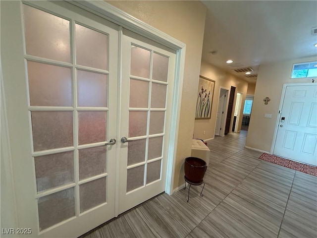 interior space featuring french doors, baseboards, tile patterned flooring, and visible vents