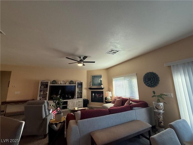 living area with visible vents and a ceiling fan