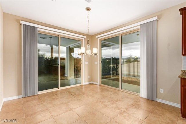 unfurnished room with light tile patterned floors, baseboards, and a chandelier