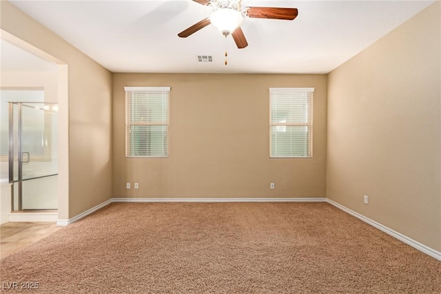 spare room featuring visible vents, baseboards, a ceiling fan, and carpet