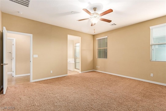 spare room featuring light carpet, ceiling fan, baseboards, and visible vents