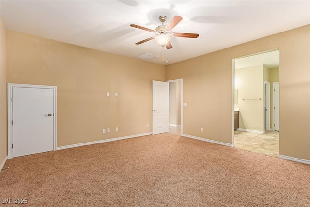 spare room with ceiling fan, light carpet, and baseboards