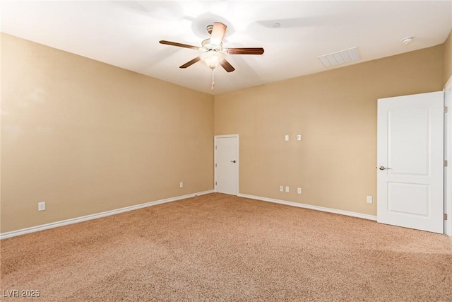 spare room with baseboards, visible vents, light colored carpet, and a ceiling fan