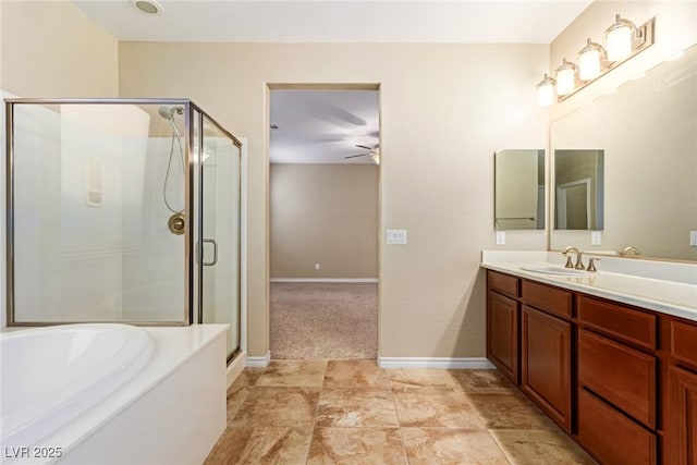 bathroom with vanity, baseboards, a stall shower, a ceiling fan, and a garden tub