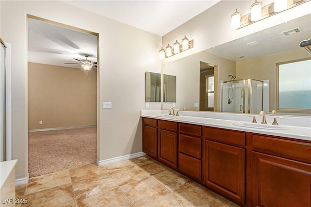 bathroom featuring a shower with shower door, double vanity, visible vents, and a sink