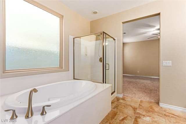bathroom featuring ceiling fan, a stall shower, baseboards, and a garden tub