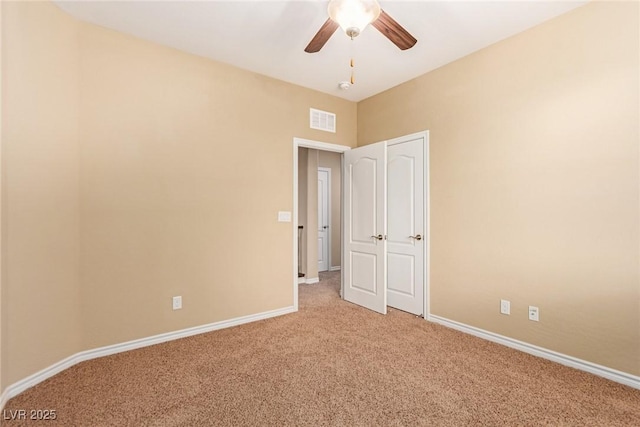 unfurnished room featuring baseboards, light colored carpet, ceiling fan, and visible vents