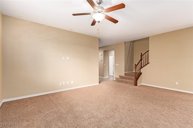 spare room featuring baseboards, stairway, light carpet, and a ceiling fan
