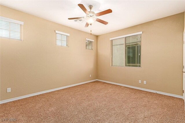 unfurnished room with carpet flooring, visible vents, baseboards, and a ceiling fan
