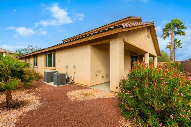 back of house featuring fence, cooling unit, and stucco siding