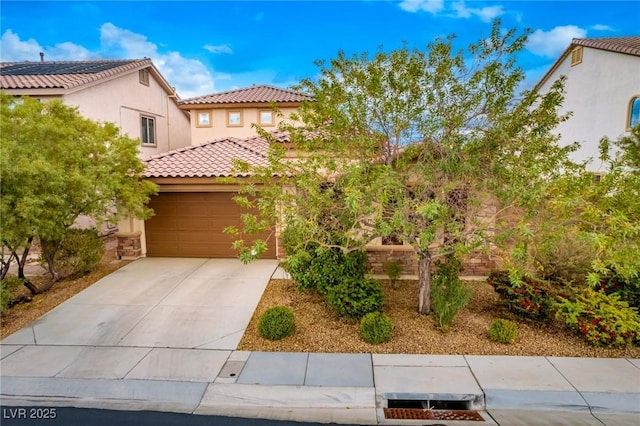 mediterranean / spanish-style house with a tiled roof, an attached garage, driveway, and stucco siding