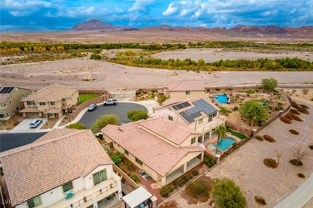 drone / aerial view with a residential view, a mountain view, and view of desert