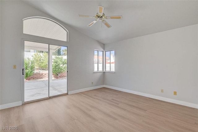 empty room with light wood finished floors, baseboards, and lofted ceiling
