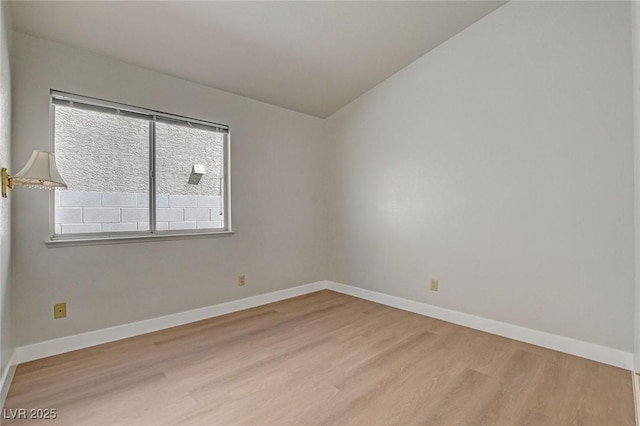 empty room featuring baseboards and wood finished floors