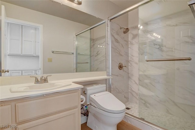 full bathroom with vanity, a marble finish shower, and toilet