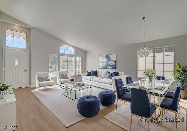 living room with a notable chandelier, wood finished floors, and a healthy amount of sunlight