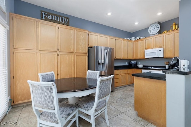 kitchen with stainless steel fridge with ice dispenser, white microwave, light tile patterned flooring, dark countertops, and light brown cabinetry
