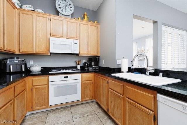 kitchen with an inviting chandelier, white appliances, a sink, and dark countertops