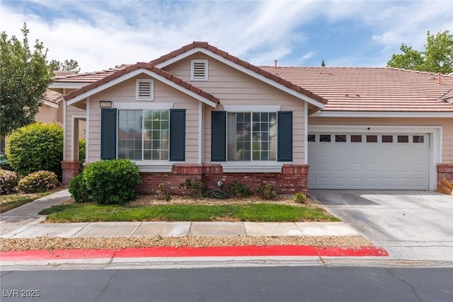 view of front of home with an attached garage, driveway, a tile roof, and brick siding