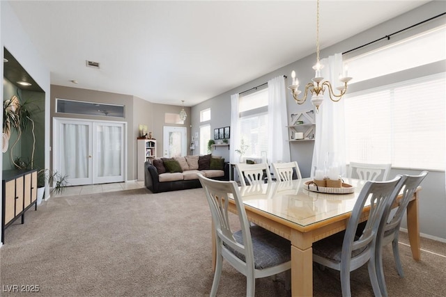 carpeted dining area featuring visible vents, baseboards, and a notable chandelier